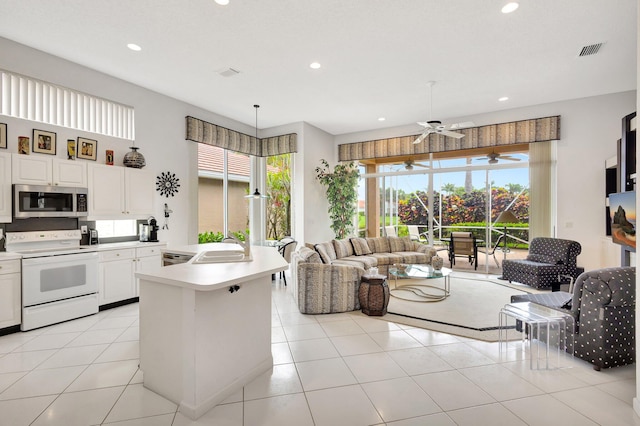 4498 Hazleton Ln, Lake Worth, FL 33449 - kitchen featuring white range with electric stovetop, stainless steel microwave, open floor plan, healthy amount of natural light, and recessed lighting