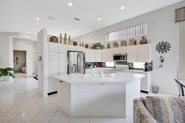 4498 Hazleton Ln, Lake Worth, FL 33449 - kitchen featuring stainless steel appliances, a sink, a center island with sink, a towering ceiling, and white cabinetry