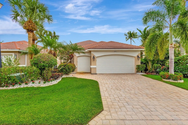 4498 Hazleton Ln, Lake Worth, FL 33449 - mediterranean / spanish home featuring decorative driveway, an attached garage, a front yard, stucco siding, and a tile roof