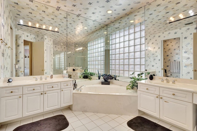 4498 Hazleton Ln, Lake Worth, FL 33449 - full bath with wallpapered walls, tile patterned floors, a stall shower, a bath, and two vanities