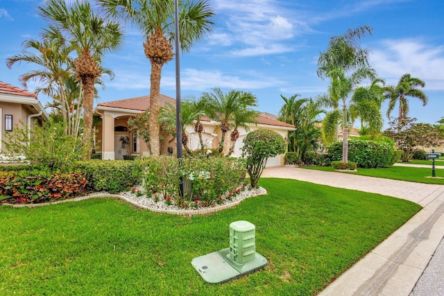 4498 Hazleton Ln, Lake Worth, FL 33449 - mediterranean / spanish house with driveway, a front lawn, stucco siding, a tiled roof, and an attached garage