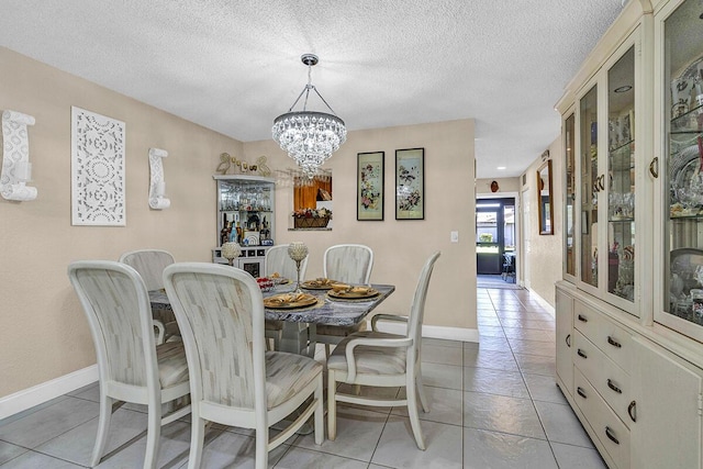 6738 Moonlit Dr, Delray Beach, FL 33446 - dining area with a chandelier, light tile patterned floors, a textured ceiling, and baseboards
