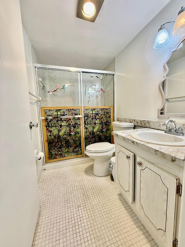 bathroom with vanity, toilet, a shower stall, and tile patterned flooring