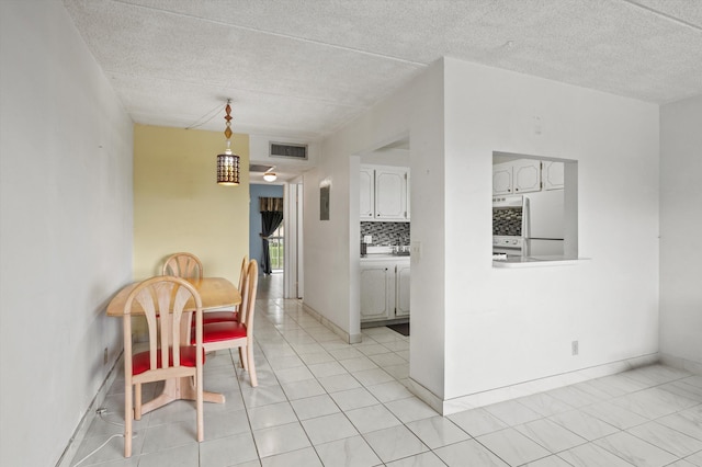 400 Village Green Cir W Unit 205, Palm Springs, FL 33461 - dining area with light tile patterned flooring, baseboards, and a textured ceiling