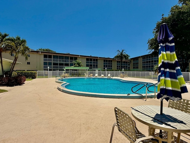 community pool with fence and a patio