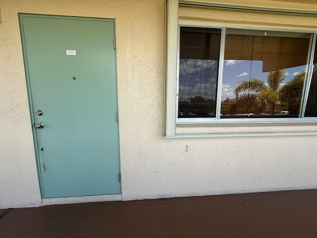 entrance to property featuring stucco siding