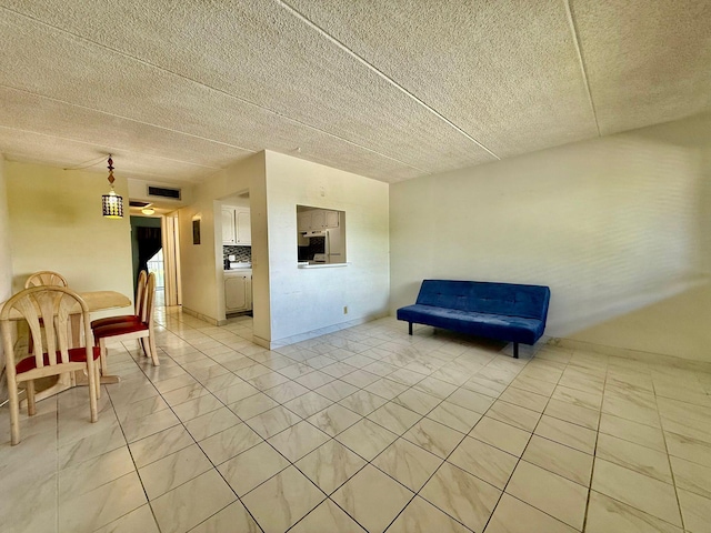 living area featuring light marble finish floors and a textured ceiling