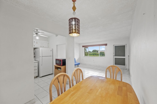 400 Village Green Cir W Unit 205, Palm Springs, FL 33461 - dining area with a textured ceiling, light tile patterned floors, and a ceiling fan