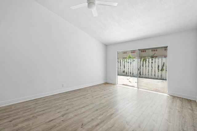 unfurnished room with wood finished floors, a ceiling fan, a textured ceiling, vaulted ceiling, and baseboards