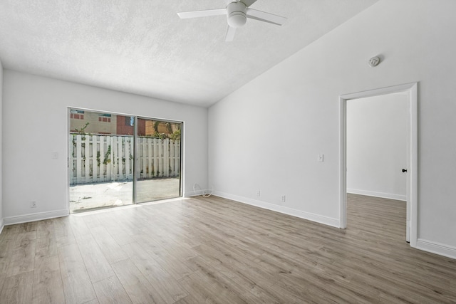empty room with wood finished floors, a ceiling fan, vaulted ceiling, a textured ceiling, and a smoke detector