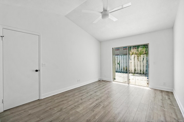 unfurnished room with vaulted ceiling, wood finished floors, a ceiling fan, and baseboards