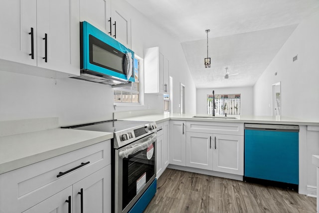 kitchen featuring dishwasher, stainless steel electric range oven, light wood-style flooring, light countertops, and white cabinetry