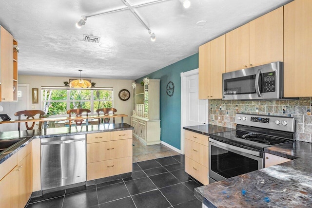 3064 Rostan Ln, Palm Springs, FL 33461 - kitchen with appliances with stainless steel finishes, light brown cabinets, dark countertops, a peninsula, and backsplash