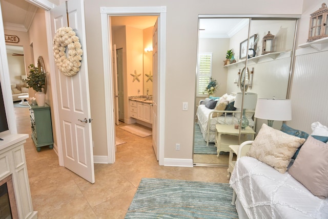bedroom featuring ornamental molding, a closet, light tile patterned flooring, and baseboards