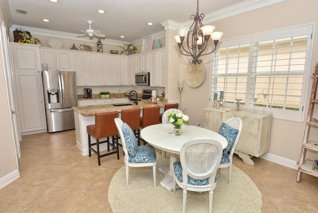 dining area with crown molding, light tile patterned floors, ceiling fan, baseboards, and a chandelier