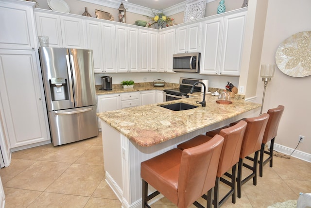 kitchen with appliances with stainless steel finishes, light tile patterned floors, a sink, a peninsula, and white cabinetry