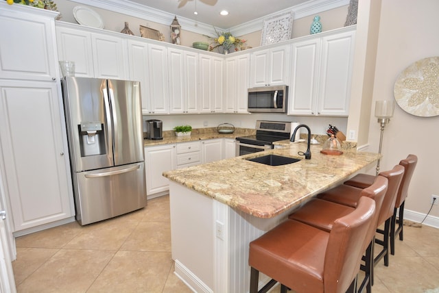 kitchen featuring stainless steel appliances, a peninsula, a sink, light tile patterned floors, and white cabinets