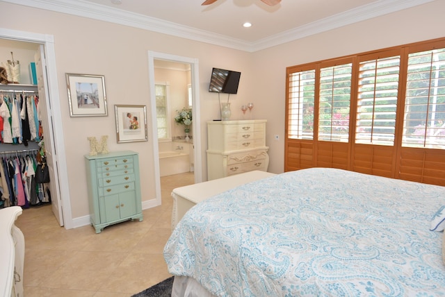 bedroom with a spacious closet, a closet, crown molding, light tile patterned floors, and baseboards