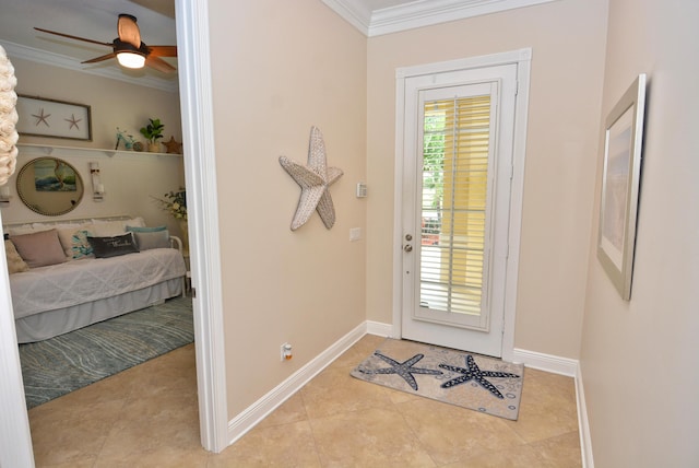 tiled foyer entrance with ornamental molding, ceiling fan, and baseboards