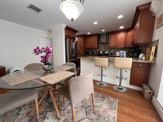 12147 Cuddington Ct, Wellington, FL 33414 - dining space featuring light wood-style floors, crown molding, recessed lighting, and baseboards