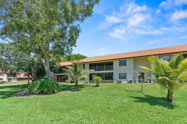 3 Via De Casas Sur Unit 204, Boynton Beach, FL 33426 - back of property featuring stucco siding, a lawn, a tile roof, and central AC