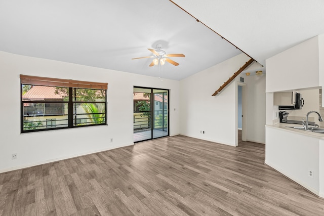 3 Via De Casas Sur Unit 204, Boynton Beach, FL 33426 - unfurnished living room with light wood-style flooring, ceiling fan, baseboards, and a sink
