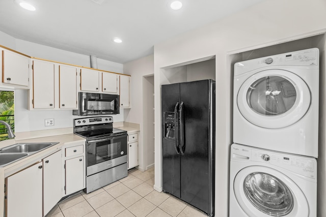 3 Via De Casas Sur Unit 204, Boynton Beach, FL 33426 - kitchen featuring black appliances, stacked washing machine and dryer, a sink, light tile patterned flooring, and light countertops