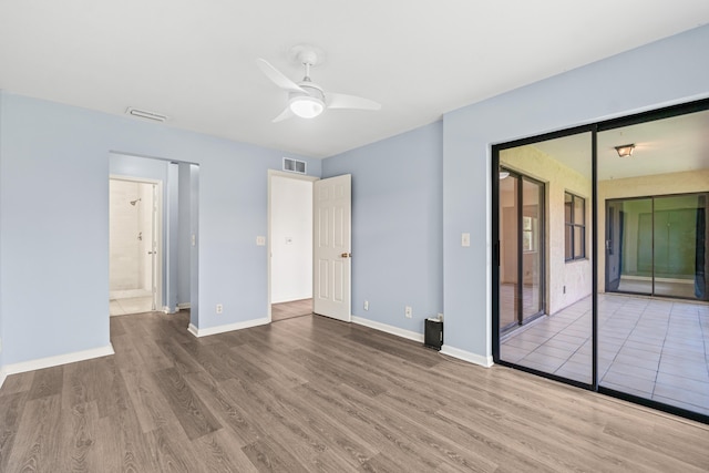 3 Via De Casas Sur Unit 204, Boynton Beach, FL 33426 - unfurnished bedroom featuring wood finished floors, baseboards, ensuite bathroom, a ceiling fan, and access to exterior