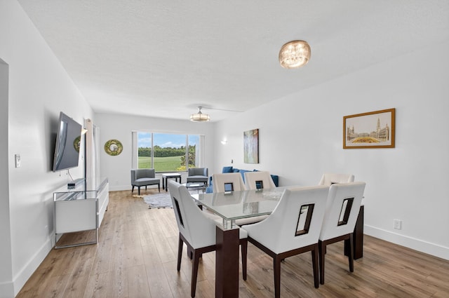 830 Greensward Ct Unit 107-H, Delray Beach, FL 33445 - dining room with light wood-style floors and a chandelier