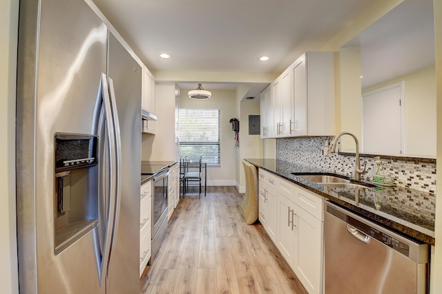 830 Greensward Ct Unit 107-H, Delray Beach, FL 33445 - kitchen featuring appliances with stainless steel finishes, a sink, light wood-style flooring, decorative backsplash, and white cabinetry