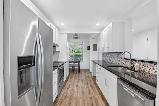 830 Greensward Ct Unit 107-H, Delray Beach, FL 33445 - kitchen featuring stainless steel appliances, light wood-style floors, dark stone counters, under cabinet range hood, and white cabinetry
