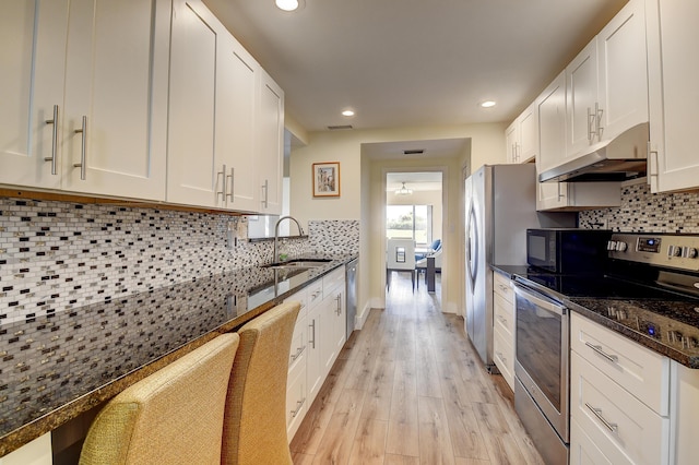 830 Greensward Ct Unit 107-H, Delray Beach, FL 33445 - kitchen featuring appliances with stainless steel finishes, under cabinet range hood, a sink, light wood-style flooring, and white cabinets