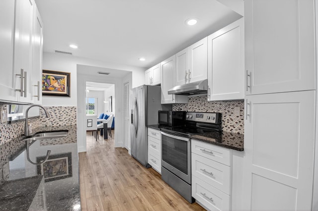 830 Greensward Ct Unit 107-H, Delray Beach, FL 33445 - kitchen featuring appliances with stainless steel finishes, under cabinet range hood, white cabinets, tasteful backsplash, and dark stone counters