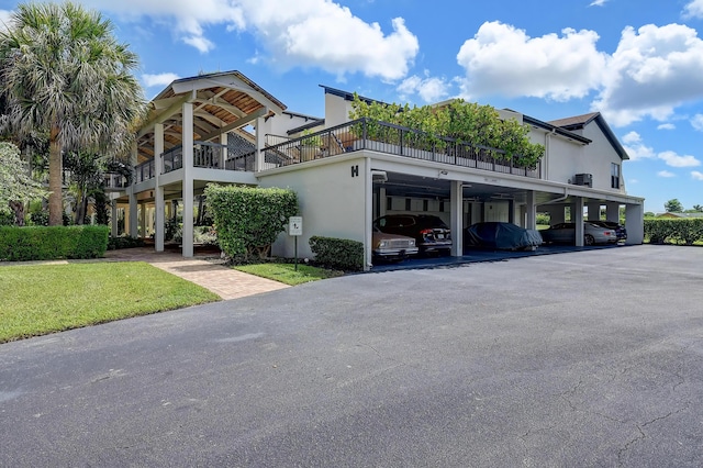 830 Greensward Ct Unit 107-H, Delray Beach, FL 33445 - view of front of house with covered parking, stucco siding, and a front yard