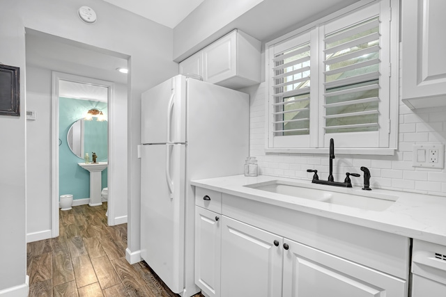 12003 Poinciana Blvd Unit 102, Royal Palm Beach, FL 33411 - kitchen featuring white appliances, dark wood finished floors, white cabinets, light stone counters, and decorative backsplash