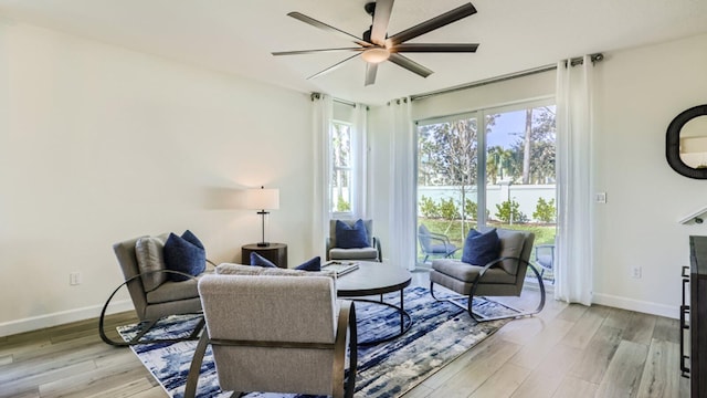 555 SE Rivergrass St, Port Saint Lucie, FL 34984 - living room with a ceiling fan, light wood-style floors, and baseboards