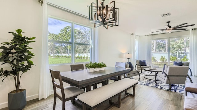 555 SE Rivergrass St, Port Saint Lucie, FL 34984 - dining space with a chandelier, light wood finished floors, a ceiling fan, and baseboards