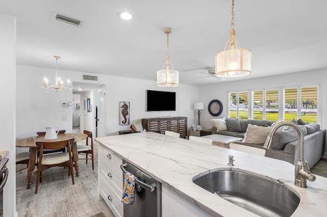 1045 Circle Ter E Unit D, Delray Beach, FL 33445 - kitchen featuring a sink, dishwasher, open floor plan, white cabinetry, and a chandelier