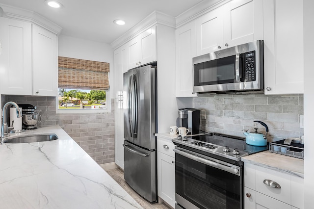 1045 Circle Ter E Unit D, Delray Beach, FL 33445 - kitchen with appliances with stainless steel finishes, a sink, white cabinetry, light stone counters, and recessed lighting