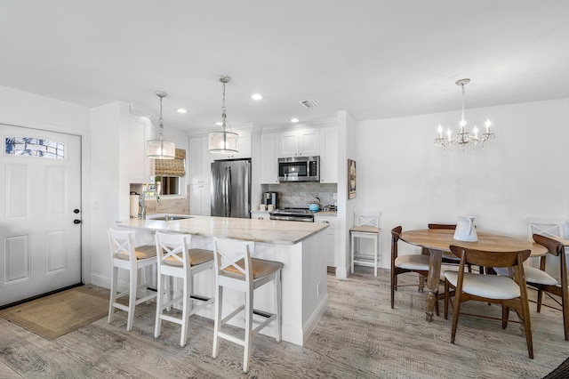 1045 Circle Ter E Unit D, Delray Beach, FL 33445 - kitchen with appliances with stainless steel finishes, a sink, light wood-style flooring, tasteful backsplash, and recessed lighting