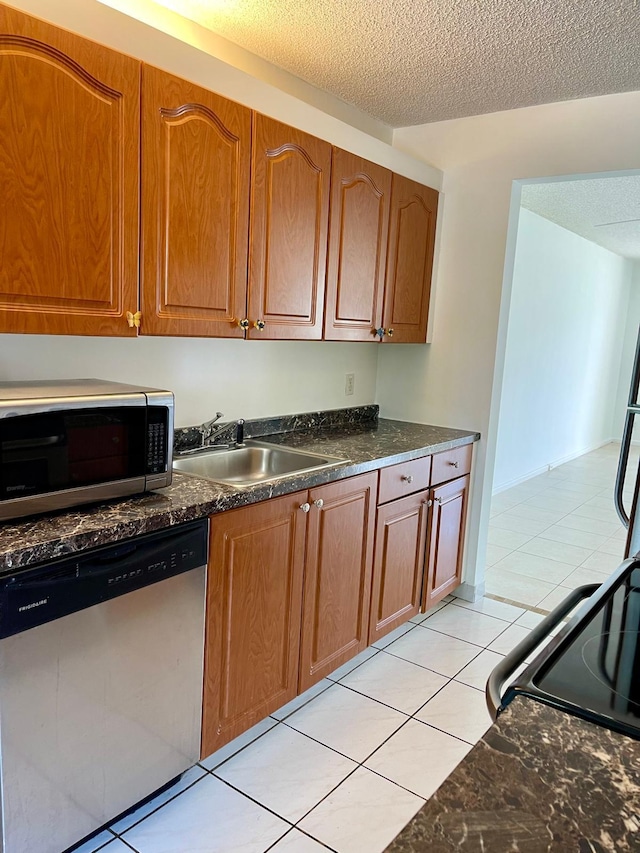 650 SW 124th Ter Unit 202P, Pembroke Pines, FL 33027 - kitchen featuring appliances with stainless steel finishes, a sink, a textured ceiling, light tile patterned flooring, and brown cabinetry