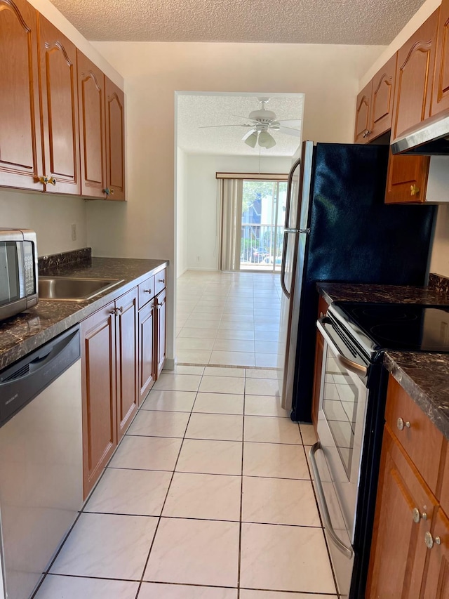 650 SW 124th Ter Unit 202P, Pembroke Pines, FL 33027 - kitchen with stainless steel appliances, dark countertops, under cabinet range hood, a textured ceiling, and a sink