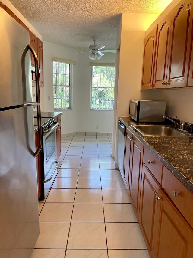 650 SW 124th Ter Unit 202P, Pembroke Pines, FL 33027 - kitchen with appliances with stainless steel finishes, a sink, dark countertops, a ceiling fan, and a textured ceiling