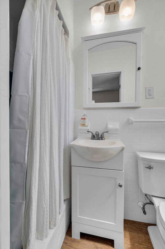 301 SW 1st Ave, Delray Beach, FL 33444 - bathroom with tile walls, toilet, a wainscoted wall, vanity, and wood finished floors