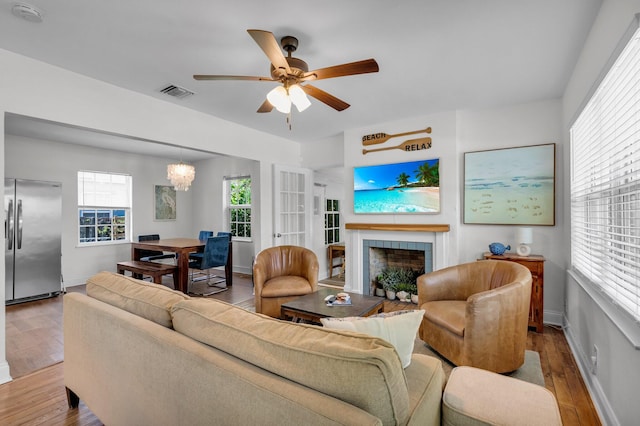 301 SW 1st Ave, Delray Beach, FL 33444 - living area with a fireplace, wood finished floors, a ceiling fan, and a chandelier