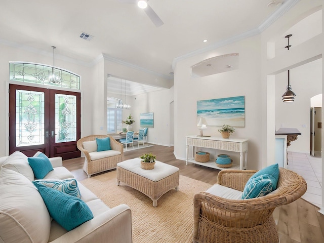 18771 Misty Lake Dr, Jupiter, FL 33458 - living room with a chandelier, ornamental molding, french doors, ceiling fan, and light wood-style flooring