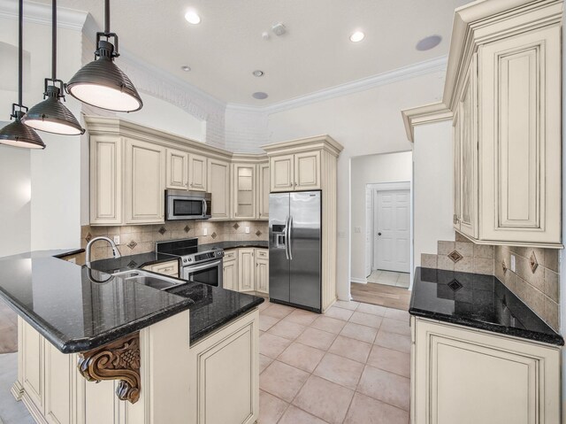 18771 Misty Lake Dr, Jupiter, FL 33458 - kitchen featuring cream cabinets, appliances with stainless steel finishes, a peninsula, a sink, and ornamental molding