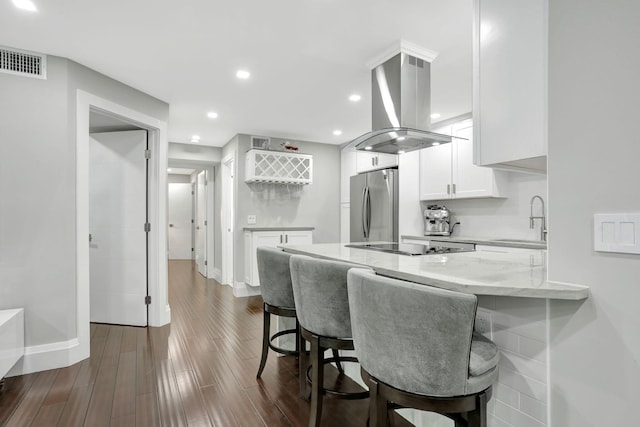 545 Trace Cir Unit 106, Deerfield Beach, FL 33441 - kitchen featuring freestanding refrigerator, a sink, island range hood, white cabinetry, and light stone countertops