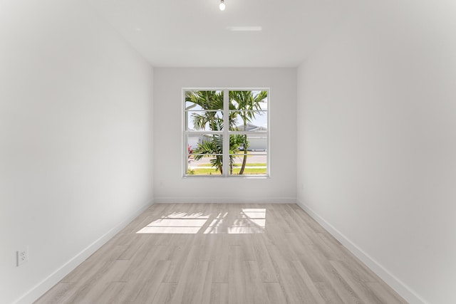 spare room with light wood-style flooring and baseboards