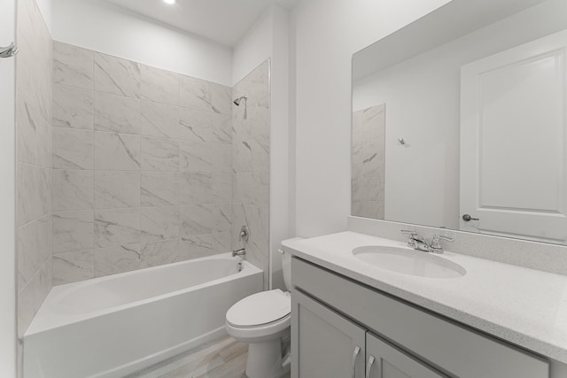 bathroom featuring toilet, vanity, shower / bathtub combination, and wood finished floors